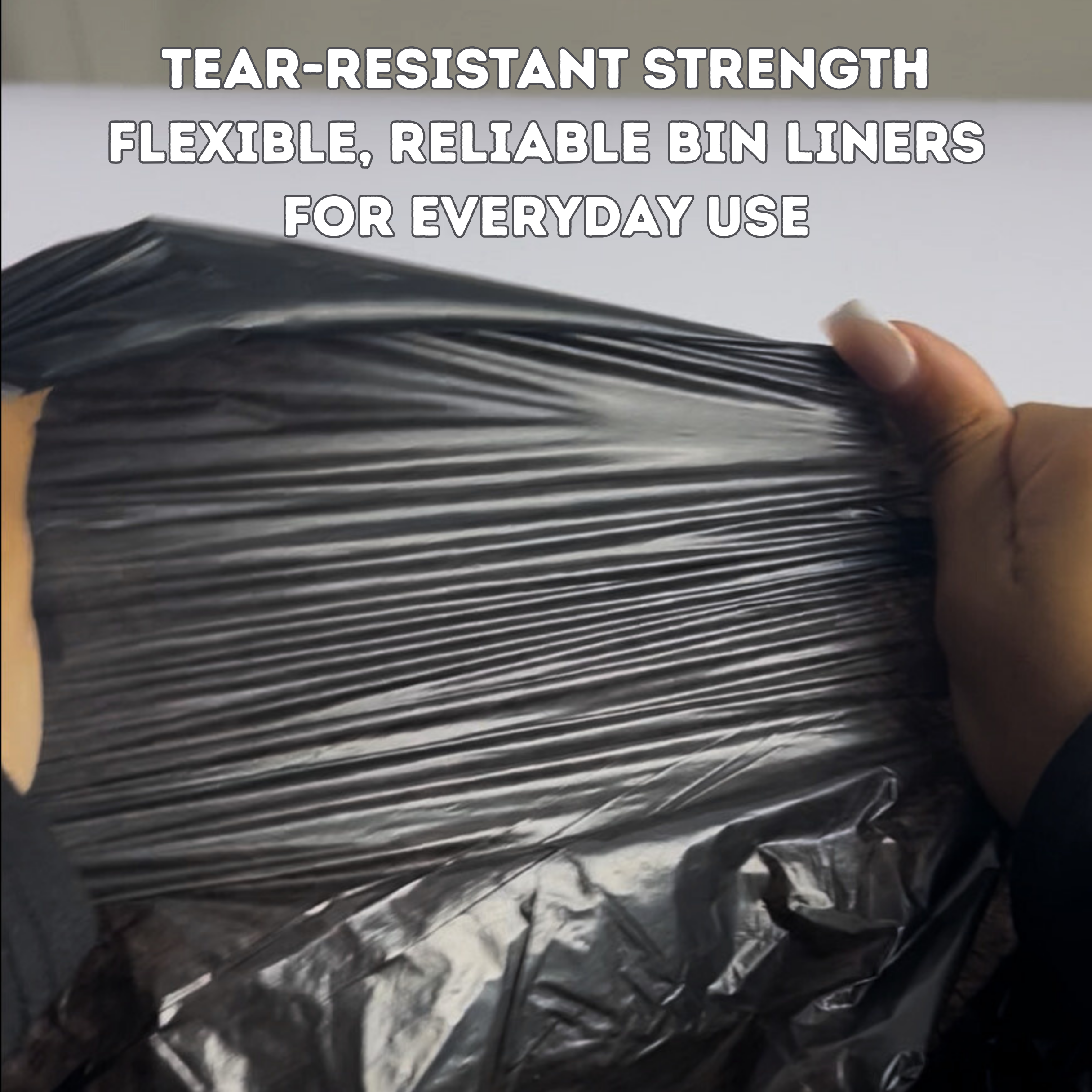 Black bin liner held by a hand with text about tear-resistant strength and reliability | Liquipak