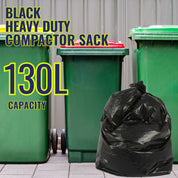 Black heavy-duty compactor sack with 130L capacity on a green bin against a gray wall.